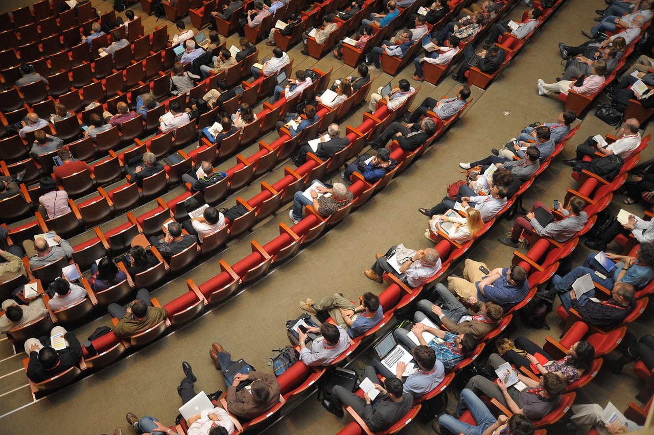 Pubblico seduto in una sala durante un evento o incontro pubblico